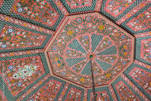 Decorated wooden ceiling at the secret garden (Le jardin secret) in Marrakech, Morocco