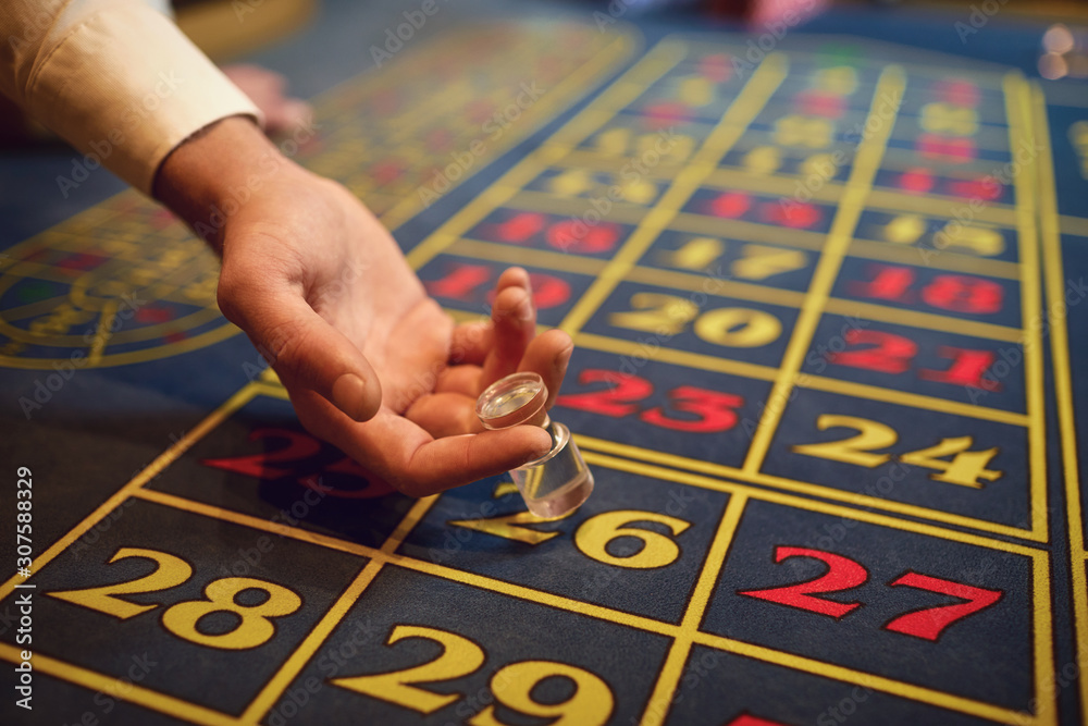 Croupier hand indicates the winning sector on the roulette table. Croupier hand indicates the winning sector on the roulette table.