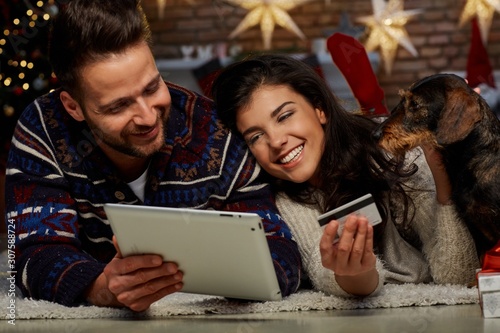 Christmas couple shopping on tablet at home