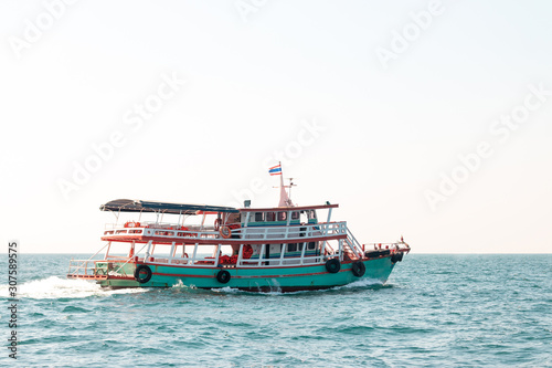 A boat brings tourists to an island in the sea in Thailand.