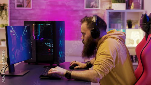 Professional game player wearing headphones in a room with colorful neons