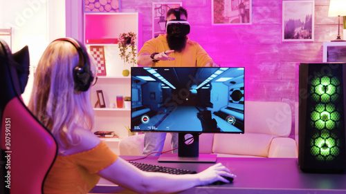Obraz na płótnie Blonde girl playing online shooter games sitting on gaming chair