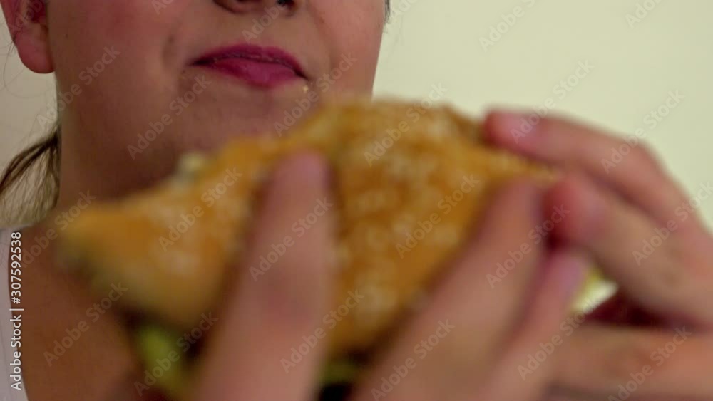 Over Sized Woman Eating A Hamburger - Slow Motion Close Up Shot Over Sized Woman Eating A Hamburger - Slow Motion Close Up Shot