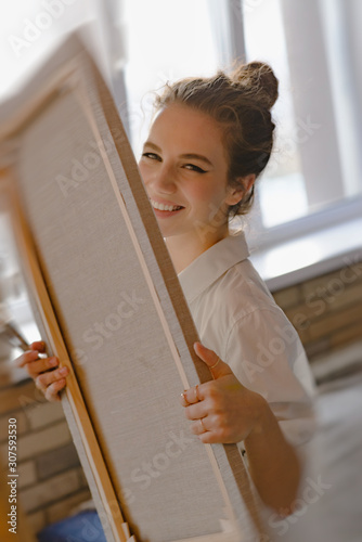 An attractive girl, the artist looks into the camera and smiles