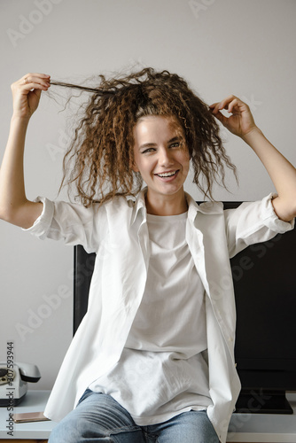 Attractive young girl playing with her hair