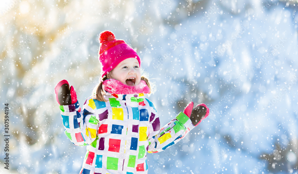 Child playing with snow in winter. Kids outdoors. Child playing with snow in winter. Kids outdoors.