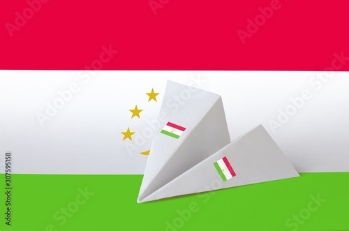 Tajikistan flag depicted on paper origami airplane. Handmade arts concept photo