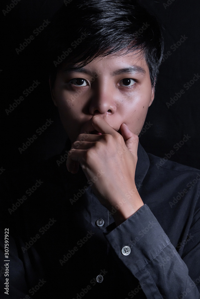  Asian 20-29s stressed face women in short hair wearing a blue shirt, standing alone on a black background. LGBTQ + concept