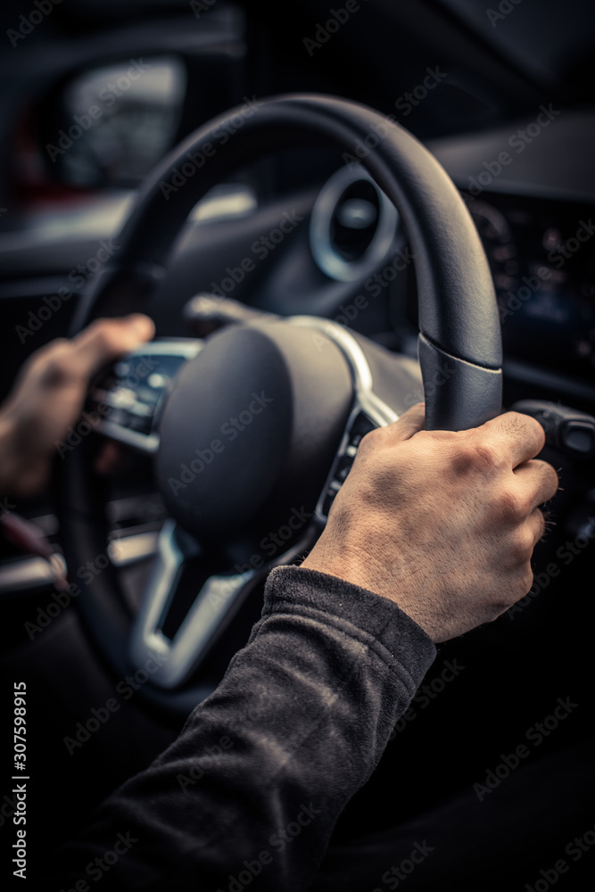Man's hand holding the steering wheel
