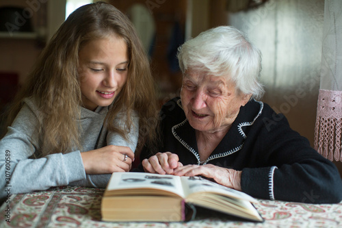 Grandmother with a little girl - granddaughter reading a book.