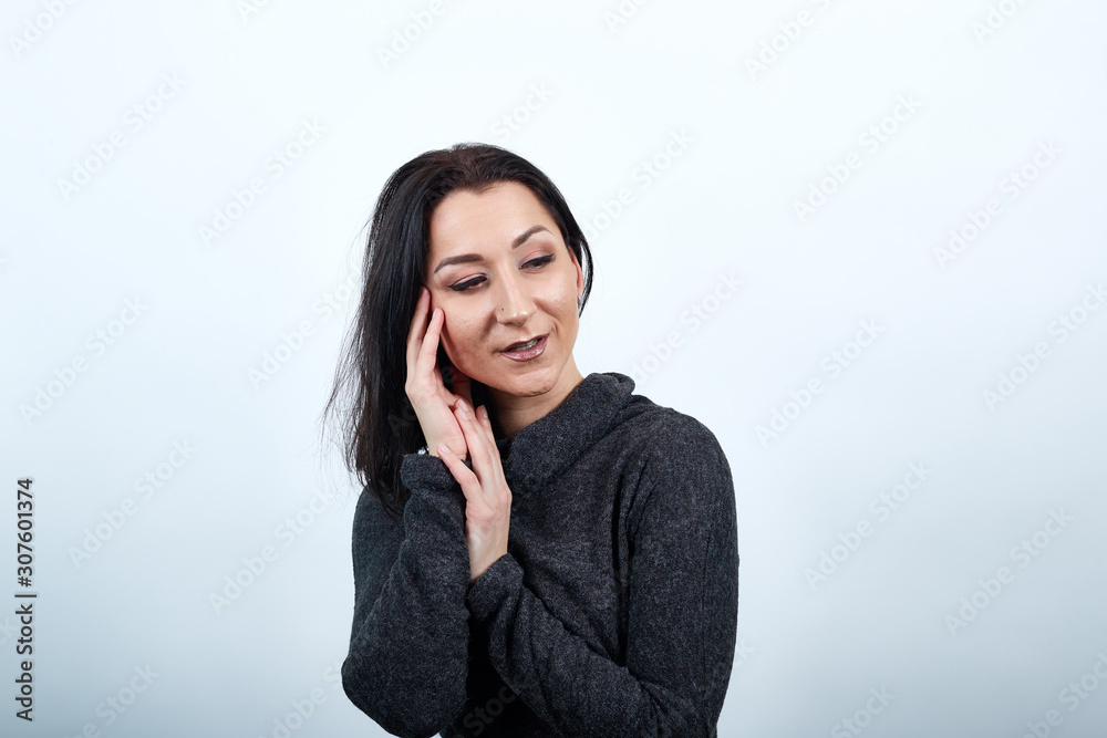 Beautiful caucasian young woman in fashion black sweater over isolated white background, closed eyes, keeping hand on head, looking pretty. Lifestyle concept