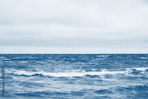Classic blue sea beach. North sea. Stormy weather: strong waves, gloomy sky, sea foam. Classic blue color sea. A place for your writing. Copy space