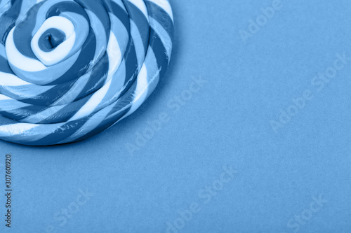 Big blue lollipop on solid blue background. Horizontal