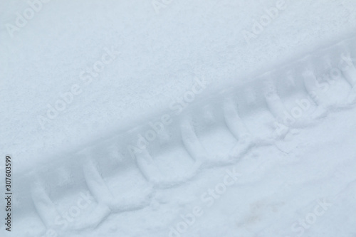 Diagonal track of car tire in pure white snow