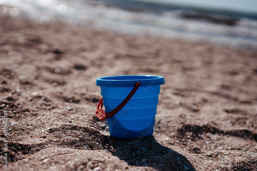 blue plastic bucket for playing in the sandbox on the beach blue plastic bucket for playing in the sandbox on the beach