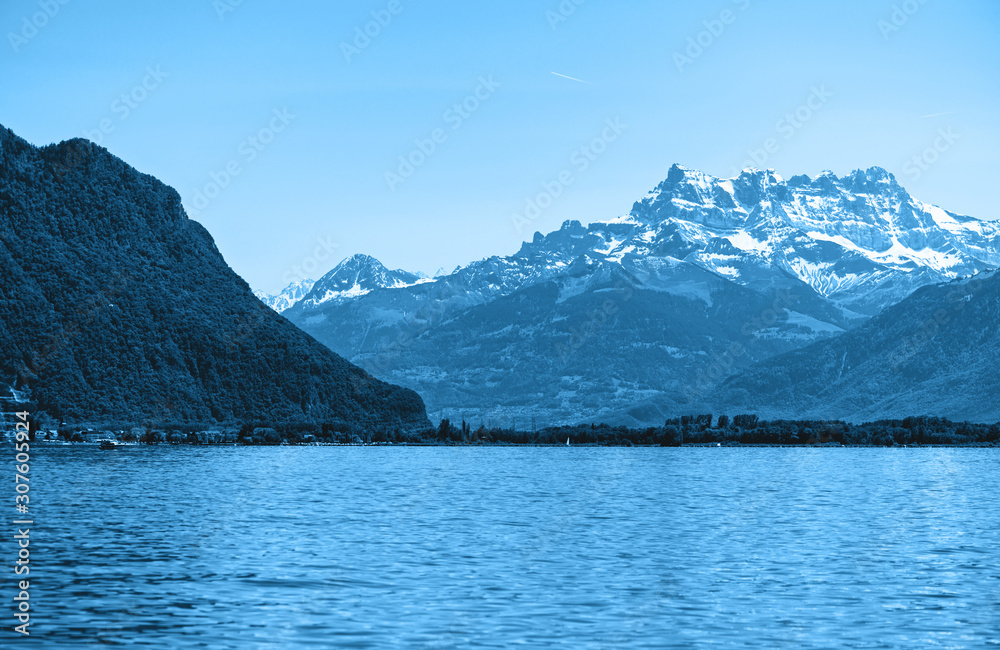 Great landscape of Geneva lake and Alpine mountains toned in blue.
