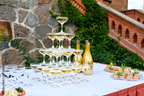 Champagne glass pyramid. Pyramid of glasses of wine, champagne, tower of champagne on wedding party.  For festive reception at the wedding on table