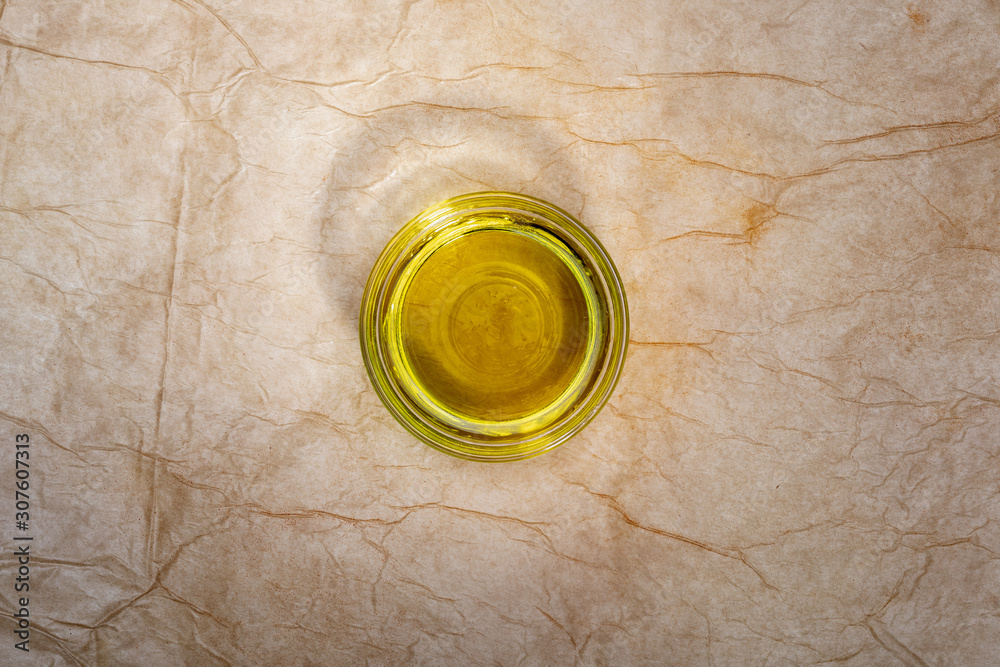 Extra virgin olive oil in glass bowl. Rustic Background. Top view. Extra virgin olive oil in glass bowl. Rustic Background. Top view.