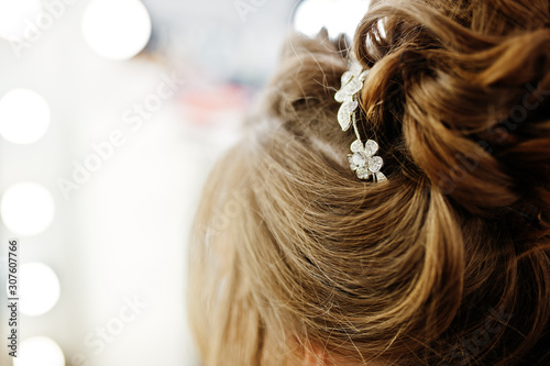 Morning of the bride preparation. Young and handsome bride at wedding day. Hairpin in the head
