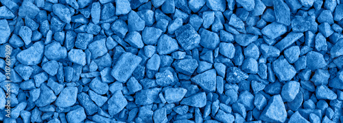 Classic blue color of the year 2020 ground stone rubble background of many small stones long banner