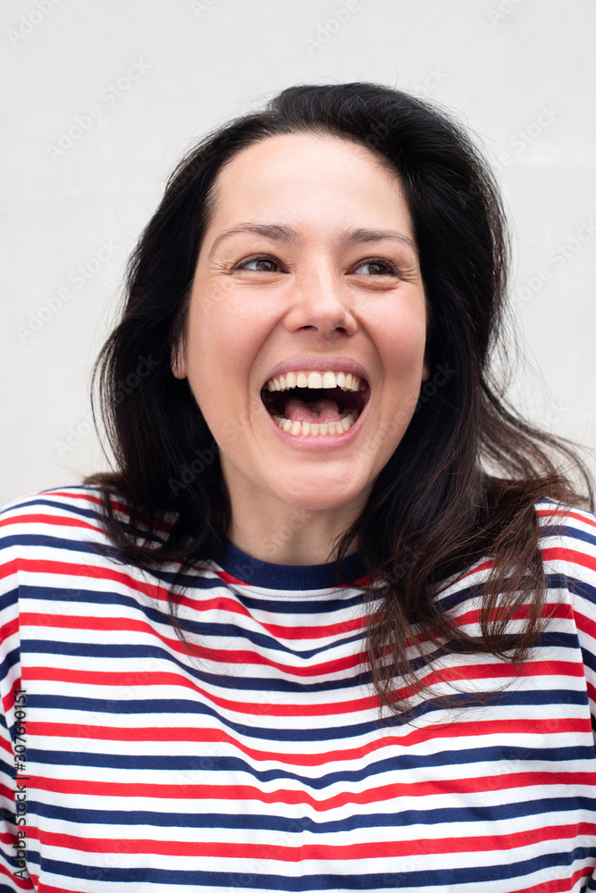 Close up happy young woman laughing against white background Close up happy young woman laughing against white background