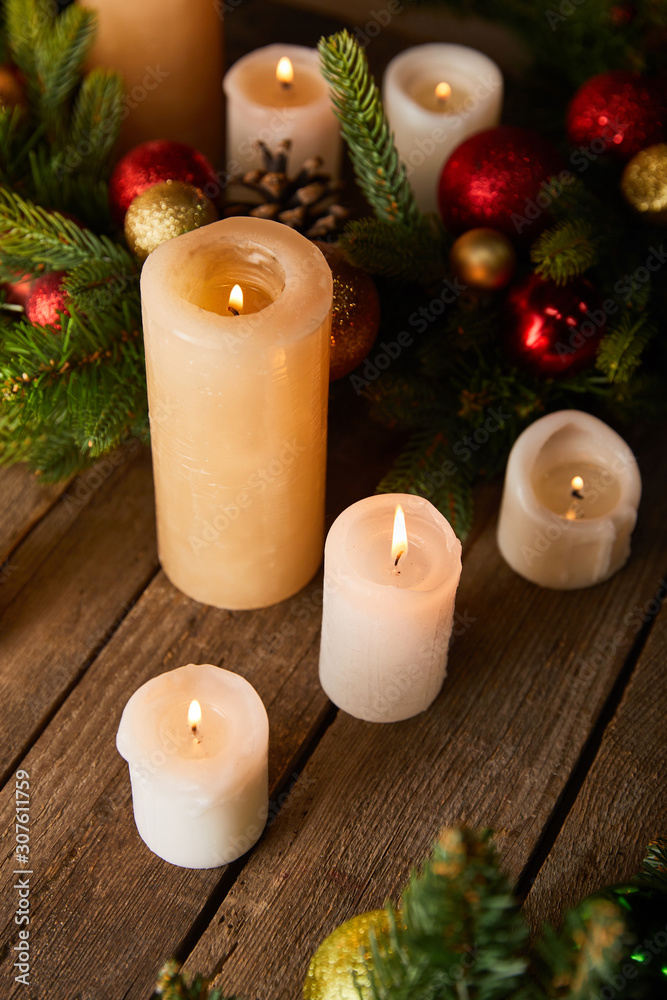 burning candles with spruce branches and christmas balls on wooden table burning candles with spruce branches and christmas balls on wooden table