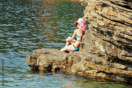 Lady sitting on the rock in the Adriatic sea