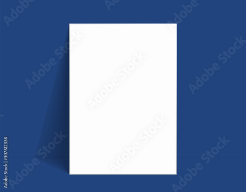 White poster mockup standing on the floor near Classic blue color wall. Blank Canvas Mockup for design.