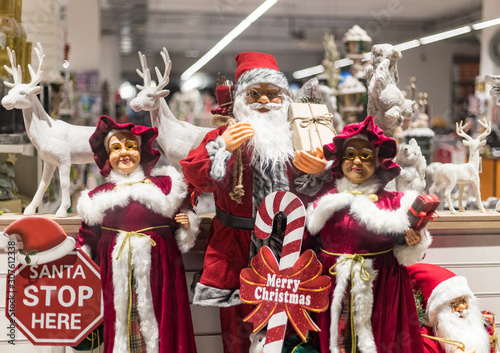 Santa Claus decorations for sale in a store window during Christmas time