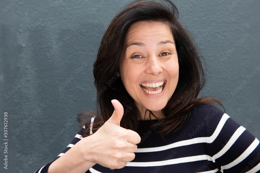 happy young woman smiling with thumbs up hand gesture