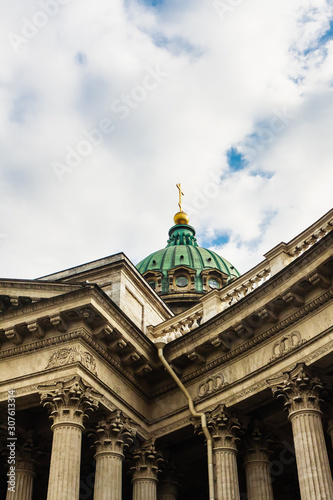 Close-up of the dome of the Kazan Cathedral with a golden cross part of a wall with columns and a frieze with windows, porticoes on a clear day. St Petersburg, Russia