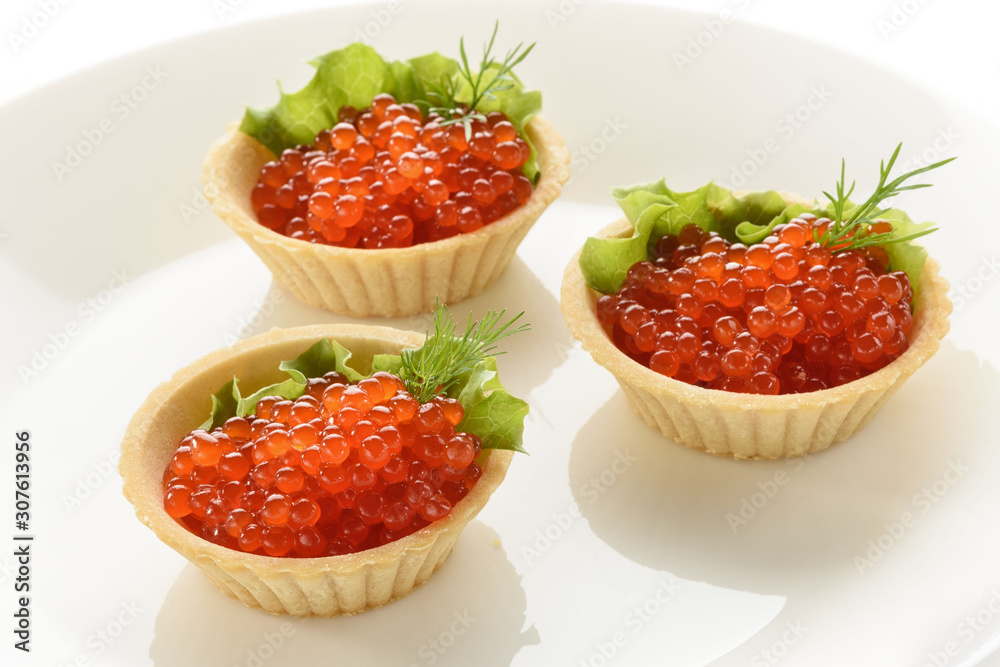 red caviar in dough tartlets with green salad on a white background red caviar in dough tartlets with green salad on a white background