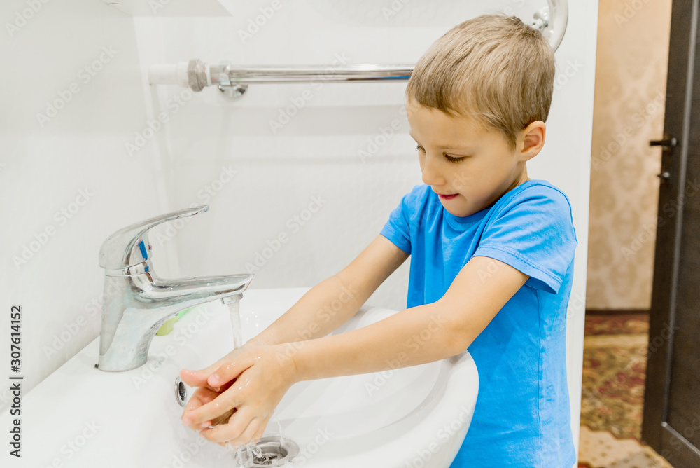 The child washes his hands in the bathroom. wash hands with soap close-up. concept of hygiene and cleanliness. tap water The child washes his hands in the bathroom. wash hands with soap close-up. concept of hygiene and cleanliness. tap water