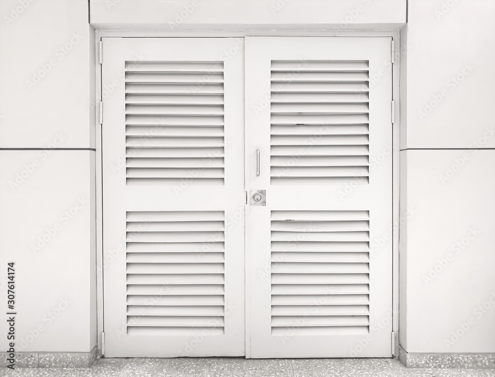 window with white shutters.The louver wooden white door is locked with the white wall. Door with horizontal vents. window with white shutters.The louver wooden white door is locked with the white wall. Door with horizontal vents.