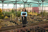 Young female business owner in her greenhouse
