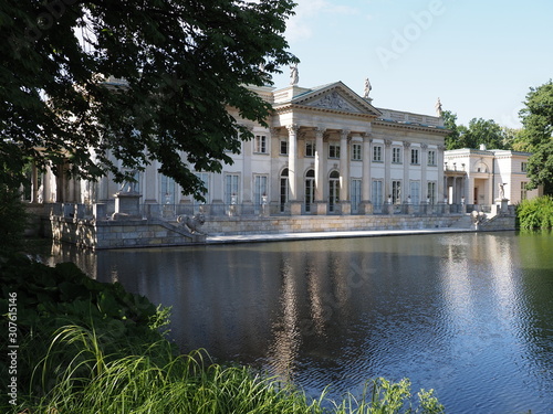 Palace on the isle behind bough at lake in baths park in Warsaw european capital city of Poland in 2019 on July.
