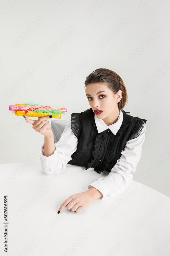 We are what we eat. Woman's eating hot-dog made of plastic, eco concept. There is so much polymers then we're just made of it. Environmental disaster, fashion, beauty, food. Loosing organic world. We are what we eat. Woman's eating hot-dog made of plastic, eco concept. There is so much polymers then we're just made of it. Environmental disaster, fashion, beauty, food. Loosing organic world.