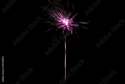 Pink festive firework on party  isolated on black