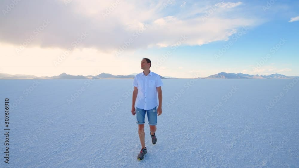 Bonneville Salt Flats near Salt Lake City, Utah with handheld pov panning of man walking on white field in summer