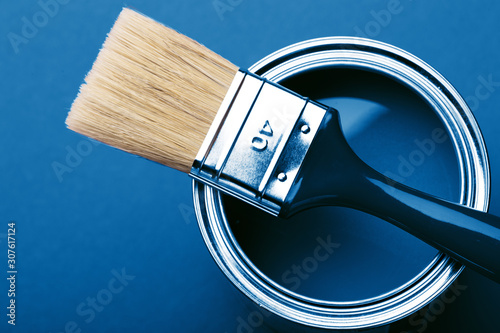 Fototapeta Naklejka Na Ścianę i Meble -  Can of blue paint with brush on blue background. Top view.