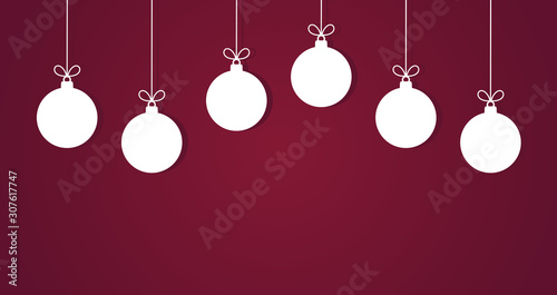 Christmas baubles hanging white ornaments on purple background.