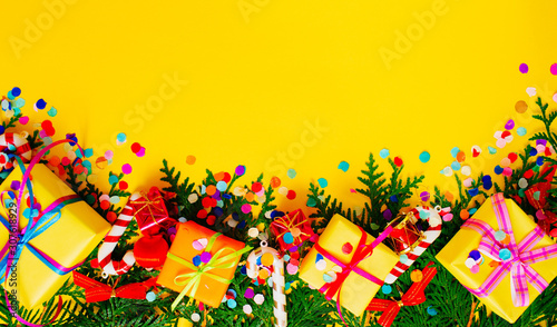 Christmas and New Year background with thuja branch, decorations and presents wrapped in craft paper with snowflakes. Flat lay, top view