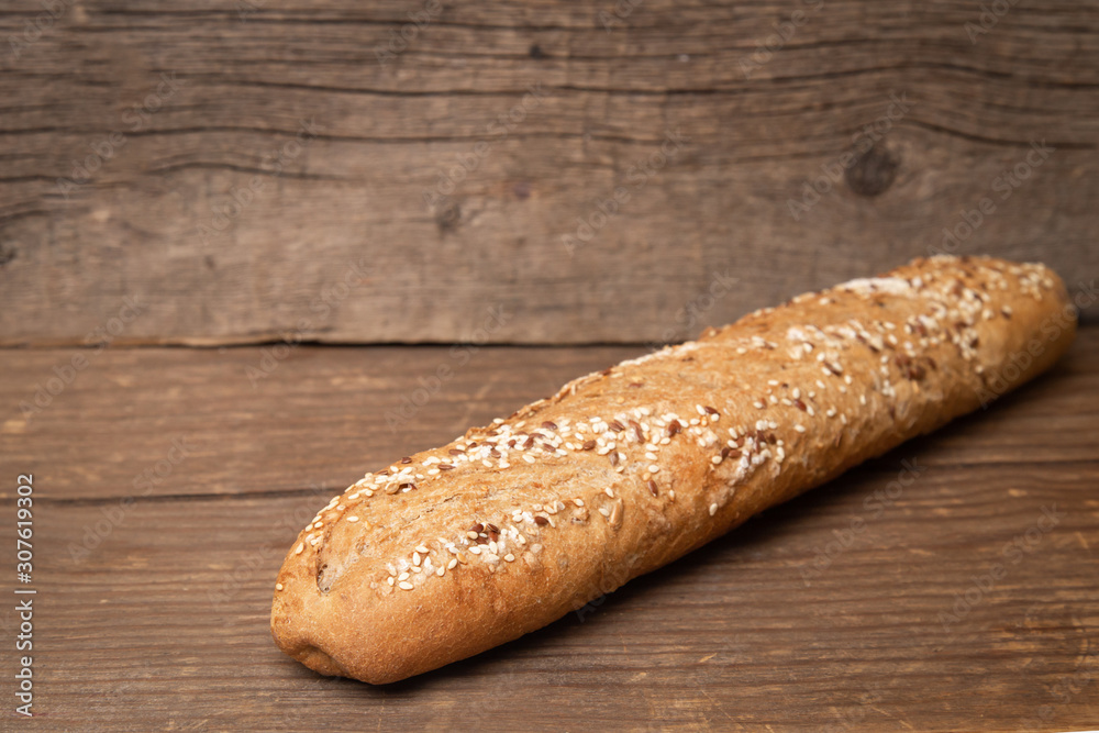 french baguette with sesame seeds on old wooden background french baguette with sesame seeds on old wooden background