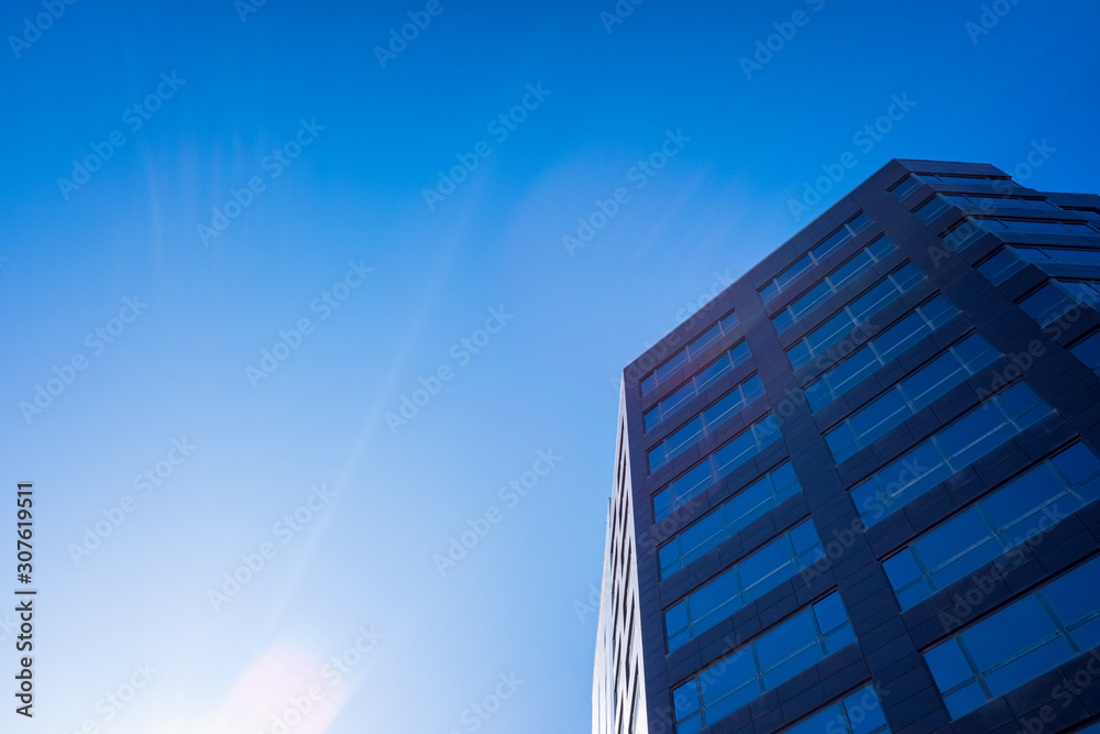 Blue sky gradient background next to a business office building.