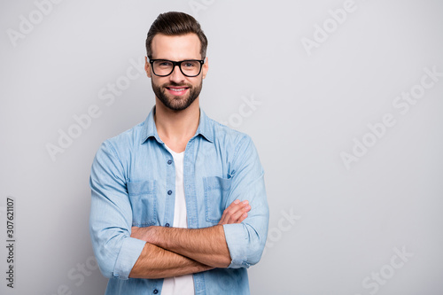 Photo of attractive guy young promoted boss chief hands crossed self-confident person friendly smiling colleagues wear specs casual denim outfit isolated grey color background