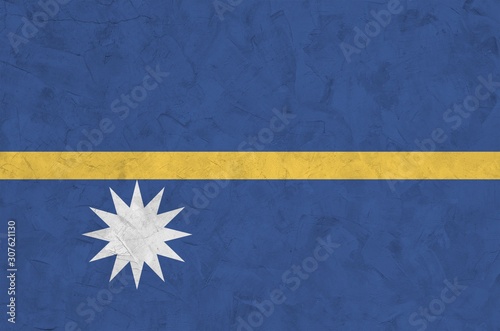 Nauru flag depicted in bright paint colors on old relief plastering wall. Textured banner on rough background photo