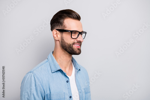 Closeup photo of amazing macho guy friendly smiling looking empty space young promoted chief wear specs casual denim outfit isolated grey color background © deagreez