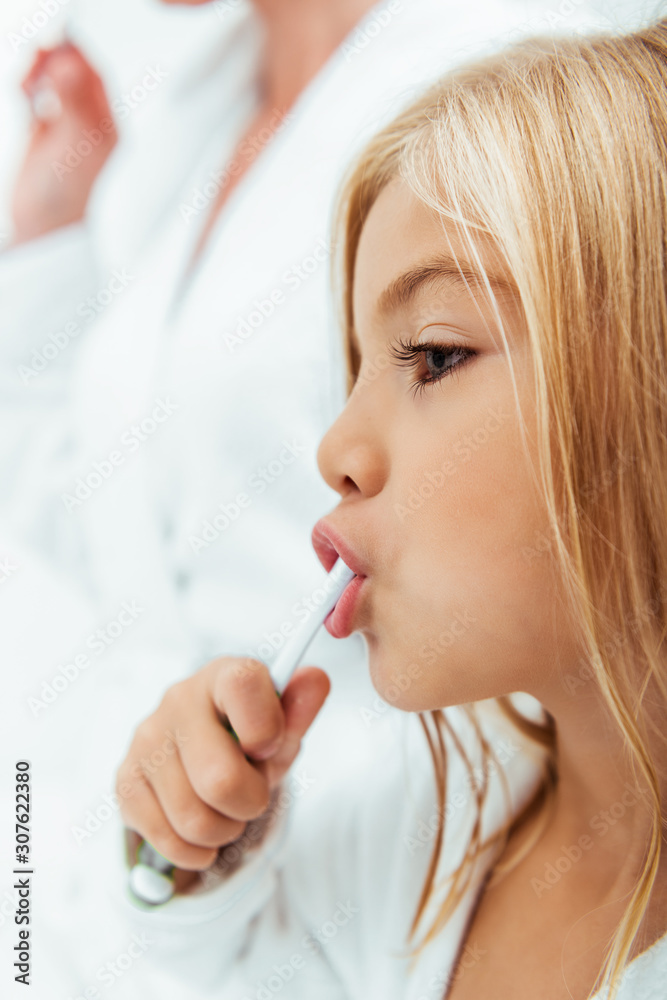 cute kid brushing teeth near mother in bathroom cute kid brushing teeth near mother in bathroom