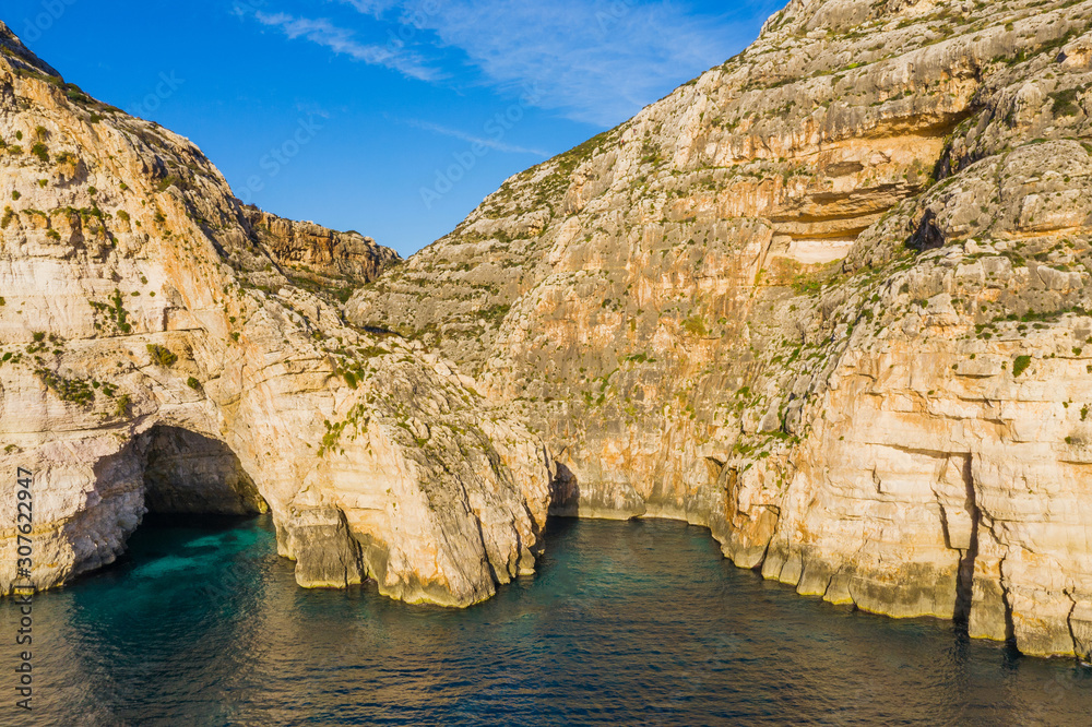 Aerial view of Blue grotto, cave and cliffs. Blue clear sky, winter, rocks. Malta island