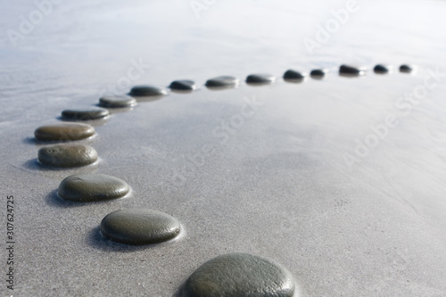 concept shallow depth of field black  stepping stones pebbles in shallow water way to success